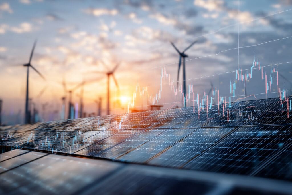 Solarzellen und Windräder bei Sonnenuntergang mit eingeblendeter Finanzgrafik
