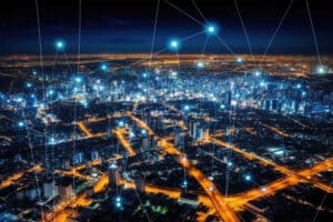 Luftaufnahme einer beleuchteten Stadt bei Nacht mit vernetzten Punkten und Linien, die digitale Kommunikation darstellen
